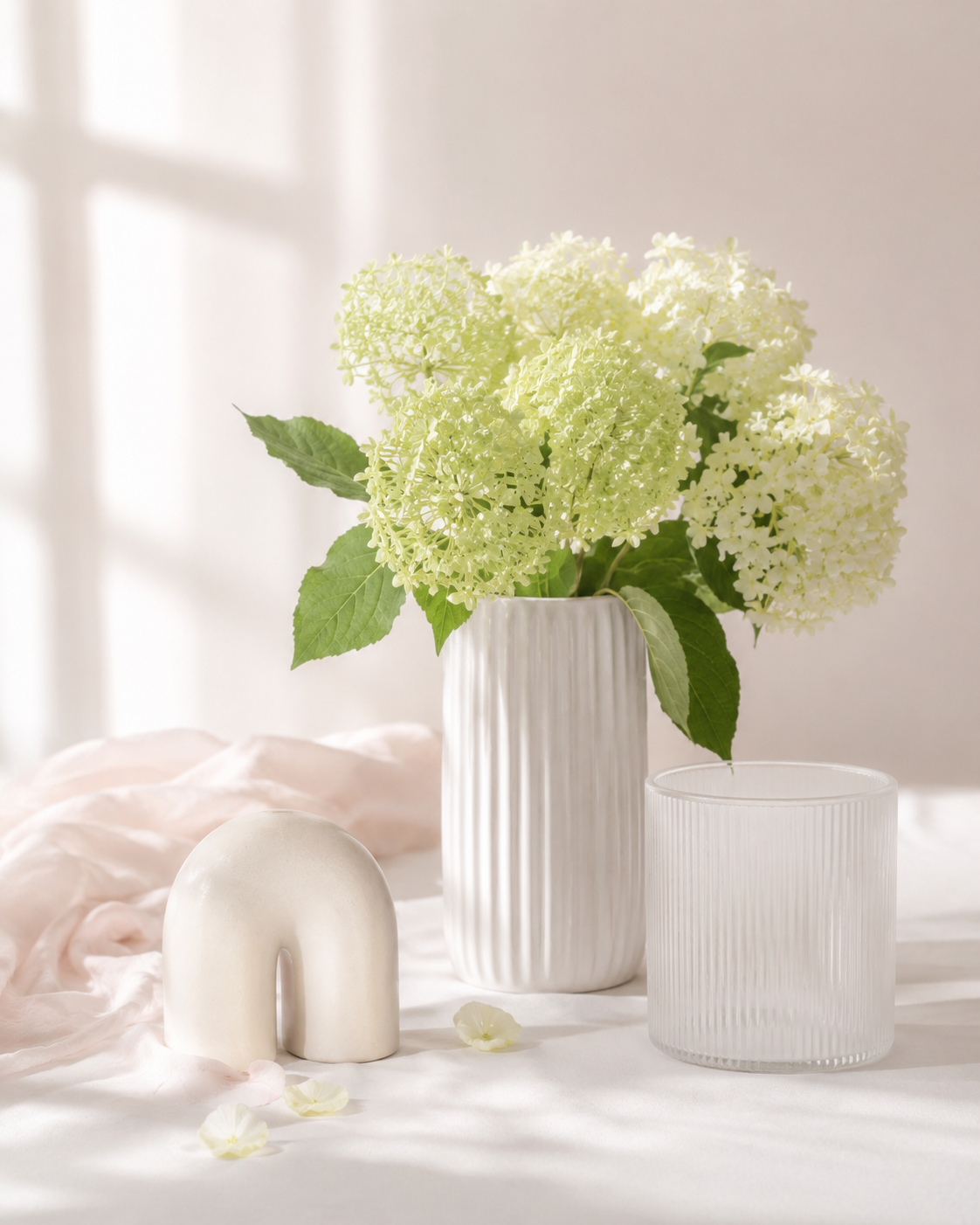 White hydrangeas in ribbed vases with soft natural light